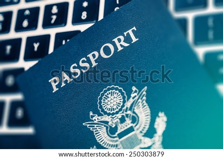 Online Travel Planning Concept Photo. United States of America Passport on the Computer Keyboard Closeup Photo.