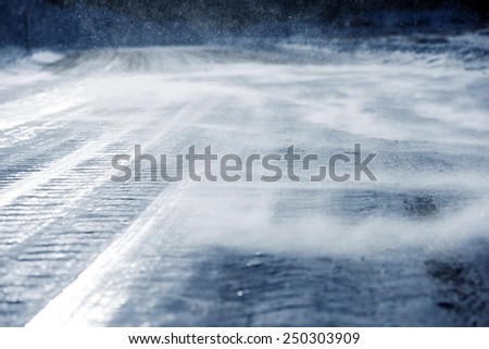 Icy Road with Drifting Snow Closeup. Dangerous Icy Road Conditions.