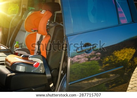 Child Car Safety Seat. Orange Car Seat Inside Small Family Van.