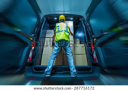Large Heavy Duty Cargo Van Loading by Men in Yellow Helmet. Shipping and Logistics Theme.