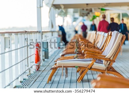 Cruise Ship Wooden Deck Chairs and Some Senior Tourists.