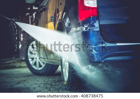Backyard Car Washing Closeup Photo. Power Washing and Cleaning Family Van.