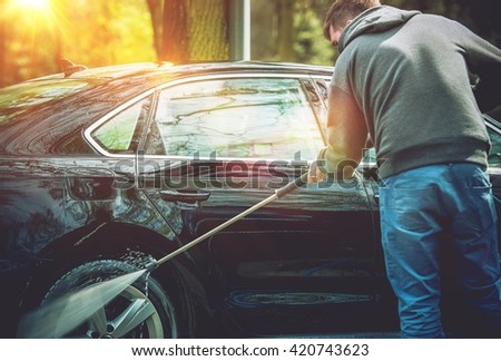 Men Washing His Car Using High Water Pressure Washer. Car Washing.