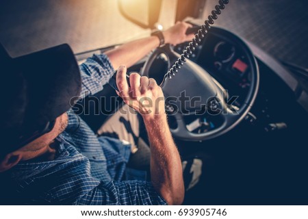 Semi Truck Driver Making Conversation with Other Truck Drivers Through CB Radio.