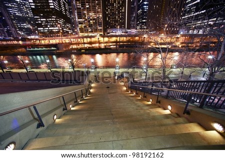 Stairs to Riverwalk in Chicago, IL USA. Chicago River and Skyscrapers at Night. Horizontal Wide Angle Photography.
