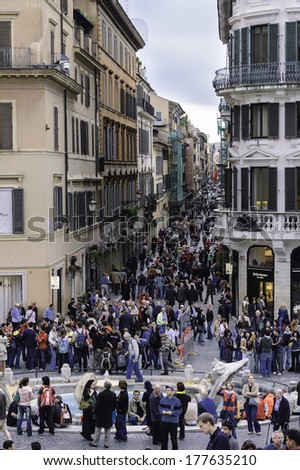 Rome, Italy - March 29, 2006 -   Crowd on the elegant place of Spain, Piazza di Spagna, with its typical houses and  fountain in the middle of the square,Rome, Italy. A place where tourists meet