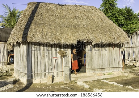 Yucatan, Mexico - December 14, 2006 : Maya woman in front of her house, Yucatan Peninsula, Mexico - roof made with palm trees