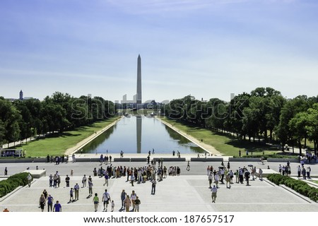 Washington, DC, USA - June 24, 2007 : Washington monument with tourists and reflections on the pond by a bright sunny day