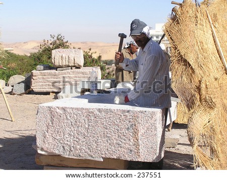 Stone-cutter of granite in Aswan, Egypt preparing an international symposium