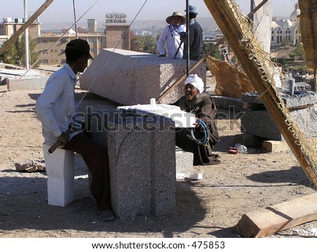 granite stone-cutter and his happy helper in Aswan, Egypt preparing an international symposium
