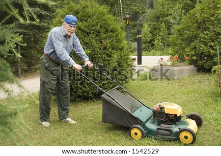Senior man mowing the lawn with a lawnmower