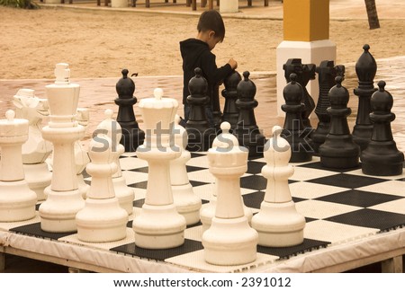 little boy playing chess during his holidays in Tulum, Quintana Roo, Mexico.