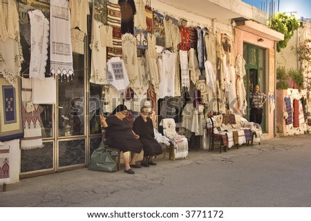 Old ladies shopkeepers waiting for customers on the  street of a Crete village, Greece