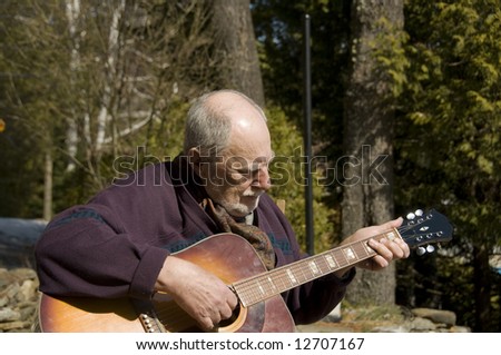 senior playing acoustic guitar in the garden