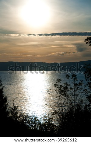 Sunset over sailing boat in St Lawrence river, Saint Jean Port Joli, Quebec, Canada