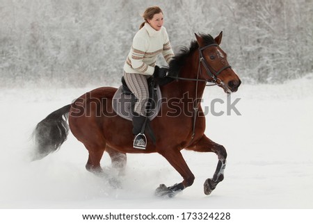 Young woman rides on horseback in winter