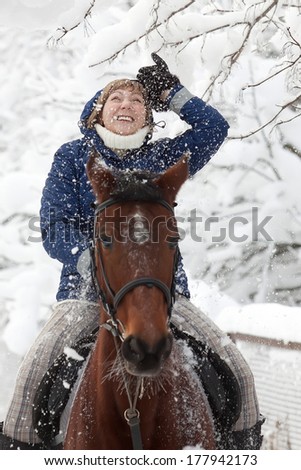Young woman on horseback at winter day