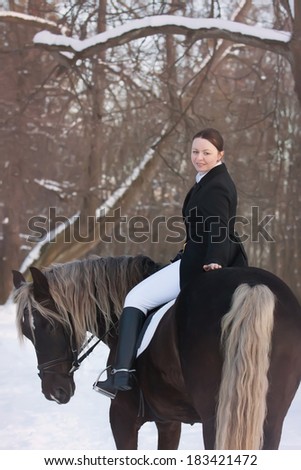 Young woman sits on horseback in spring forest
