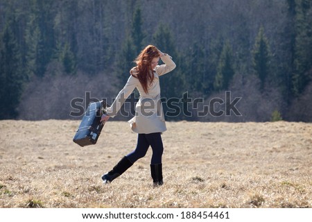 Beautiful red haired girl holding vintage bag
