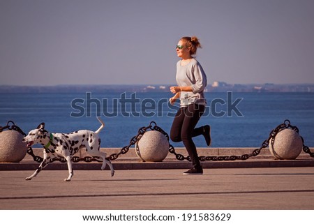 Young woman does a morning jog on a shore of Gulf of Finland