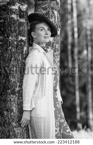 Young beautiful woman posing in vintage clothes. Black and white photo.