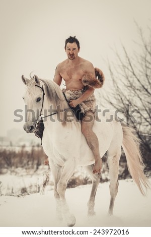 Wild man on horseback at winter day