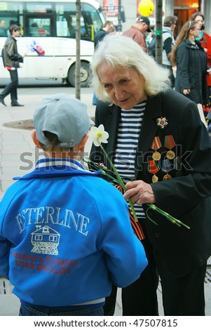 ST.-PETERSBURG, RUSSIA -  MAY 9: The senior woman - veteran of the second world war and a young boy on a holiday of Victory on May 9, 2008, in St.-Petersburg, Russia.
