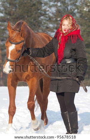 Girl in red headscarf and Russian Don horse at winter day