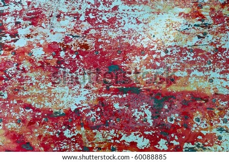 The texture of flaked red paint on metal surface