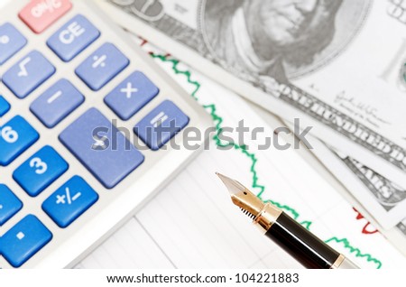 Pen,calculator and dollars on chart closeup. Business concept