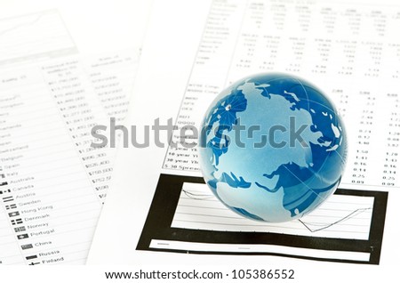 Glass globe and pen on finance chart