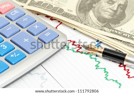 Pen, calculator and dollars on chart closeup