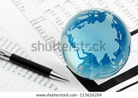 Glass globe and pen on finance background