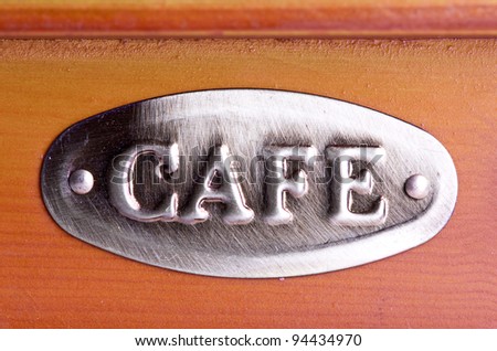 An old coffee shop sign on wooden wall. Space for text