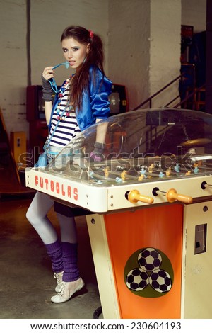 Young woman in USSR 80s style posing in a museum of gaming machines in Moscow