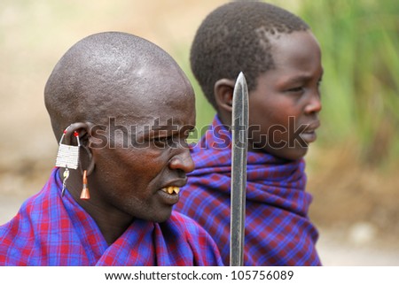 SERENGETI, TANZANIA - JAN 22: Unidentified African men in traditional dress from Masai tribe shown in the savannah in the Serengeti National park on January 22, 2008