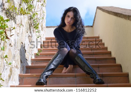 Innocent beautiful young woman in heavy boots on the stairs