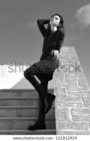 Sensual beautiful girl staying  on the stairs of the old house under bright sun. Tuscan, Italy. Black and white image