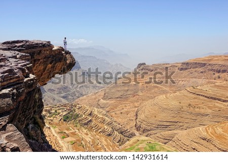 YEMEN - MARCH 6: A man dressing in typical traditional clothes standing on the edge of the cliff  on Mar 6, 2010 in Yemen. Among other arabic countries, in 2012 Yemen became a site of civil conflicts