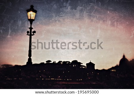 Lighting torch and cityscape silhouette of Saint Peter's basilica Vatican Rome Italy in twilight. Filtered image