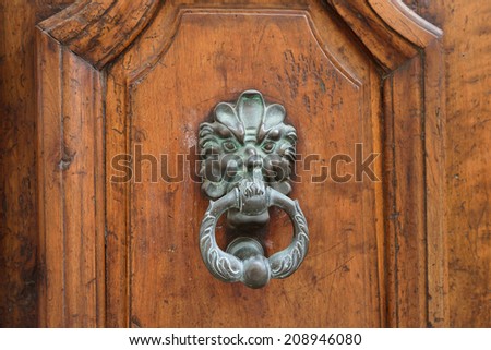 An ancient bronze detail on the old medieval door. A doorknob