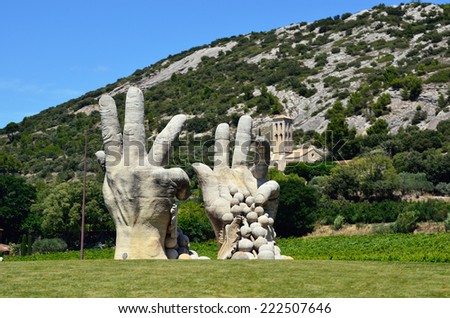 PROVENCE, FRANCE - JULY 11, 2014: Modern sculpture - peasant hands with grapes. Provence is one of the largest agricultural regions in France