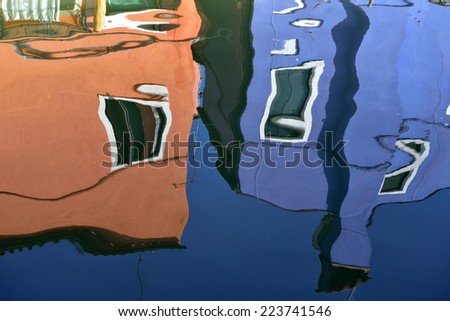 The reflection of a colorful houses in water canal, Burano island, Venice,  landmark of Veneto region, Italy