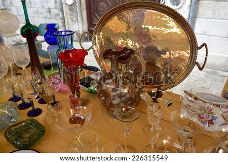 VENICE, ITALY - SEP 21, 2014: Old glassware, glasses, wine glasses, silver, arts, etc for sale at Venice Campo San Maurizio flea market. This flea market serves the professional antique dealers.