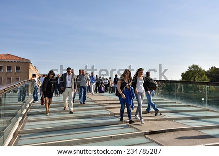 VENICE, ITALY - SEPT 23, 2014: People hurry to work in the morning, pass the bridge of the Constitution in Venice. Most residents work outside the historic city