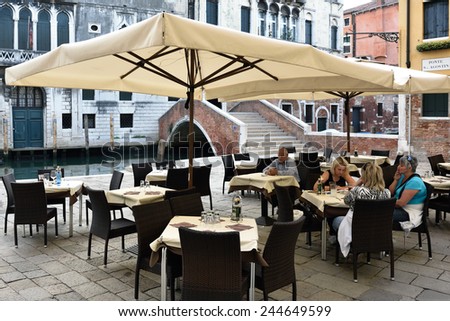 VENICE, ITALY - SEPT 21, 2014: People visit street cafe on in Venice at morning time. This is the typical Venetian cafe