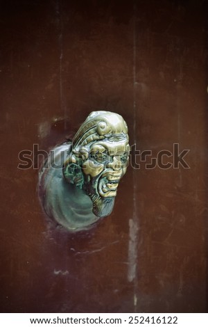 Demon. Ancient door knob on a wooden door in Venice, Italy. Filtered image, old lens effect applied, also  grunge and vignette
