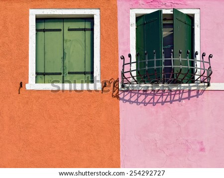 Burano island, Venice. Windows with green shutter on colorful wall.  Colorful houses island and landmark of Veneto region, Italy