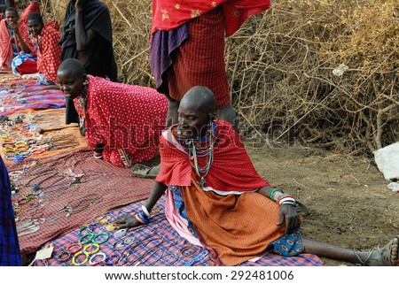 MASAI MARA, KENYA - AUG 23, 2010: Local sellers from Masai tribe offer goods in the market. Traditional handmade accessories very popular souvenir from Kenya for most tourists