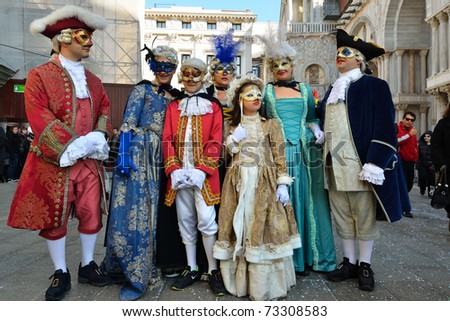 VENICE - MARCH 7: A family masked in costume in St. Mark\'s Square during the Carnival of Venice on March 7, 2011. The 2011 carnival was held from February 26th to March 8th.